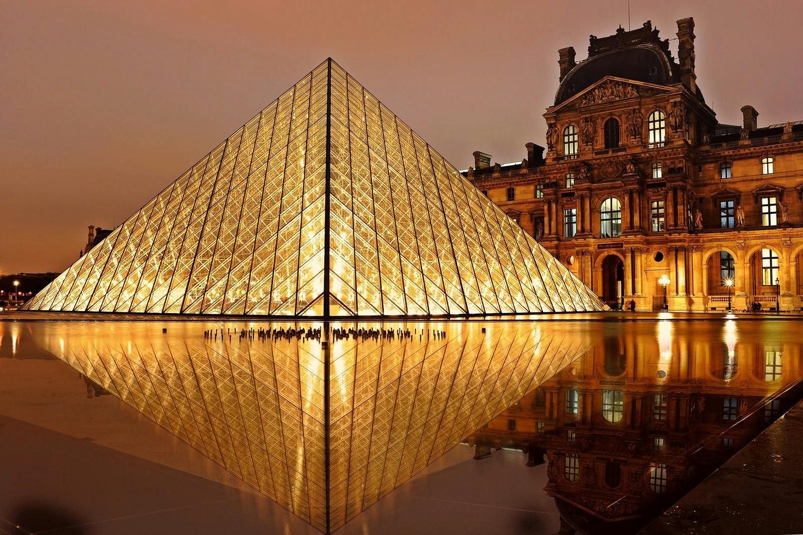 Stunning nighttime view of the illuminated Louvre Pyramid in Paris, France. - Photo by Pixabay